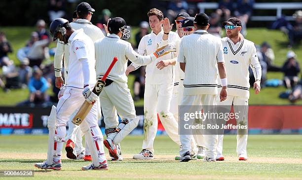 Mitchell Santner of New Zealand celebrates with his team-mates after taking the wicket of Dimuth Karunaratne of Sri Lanka during day two of the First...