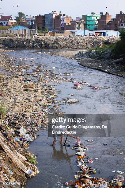 man sifting through garbage in bagmati river - bhagmati river stock pictures, royalty-free photos & images