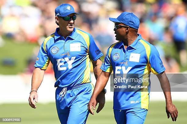 Andy Bichel and Brian Lara of the Legends talk while walking back to their fielding spots during the WA Festival of Cricket Legends Match between the...