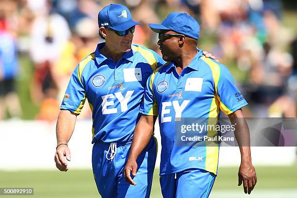 Andy Bichel and Brian Lara of the Legends talk while walking back to their fielding spots during the WA Festival of Cricket Legends Match between the...