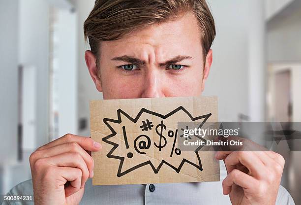 man holding swear word sign in front of his mouth - taco fotografías e imágenes de stock