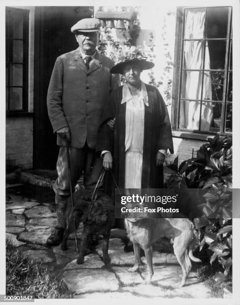 Portrait of Sir Arthur Conan Doyle and his wife in their garden, with their pet dog at their feet, 1927.