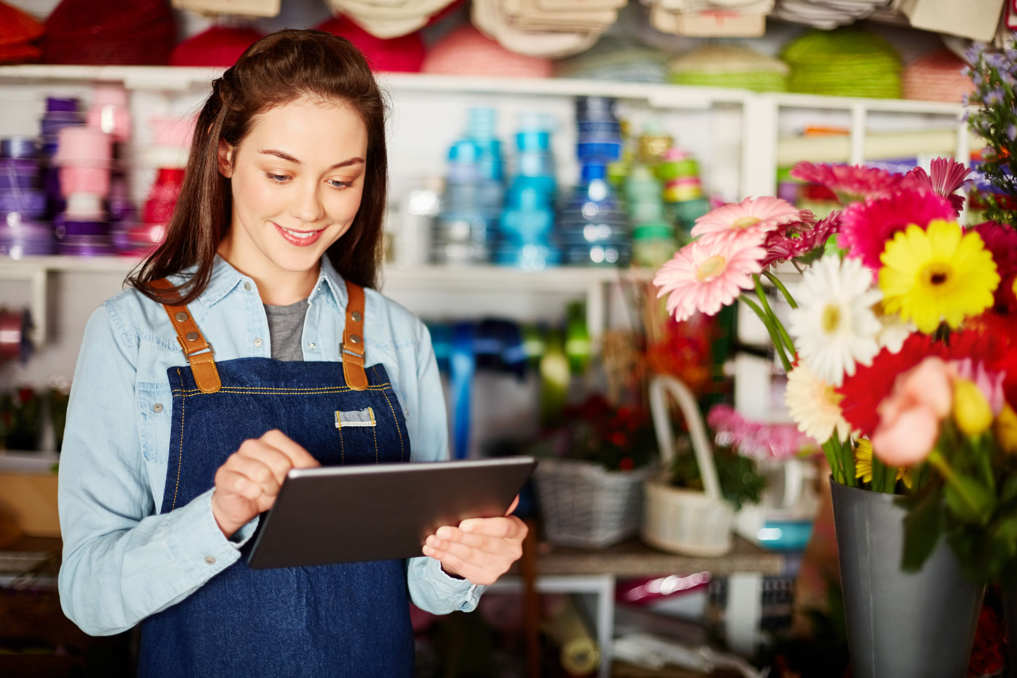 Female florist using tablet computer in flower shop Female florist using tablet computer in flower shop