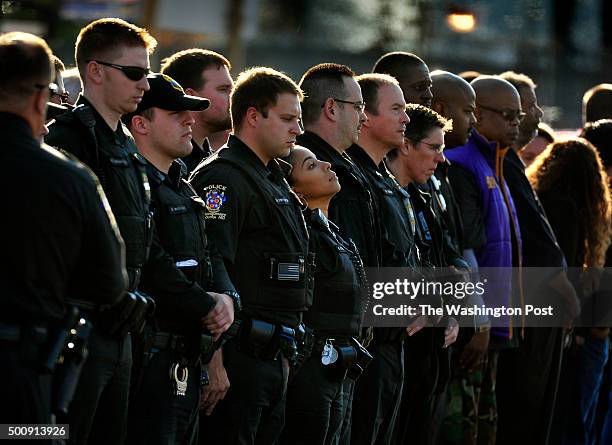 Montgomery County police officers and friends stand at attention just moments before a procession on Randolph Rd. Passed by in front of the 4th...