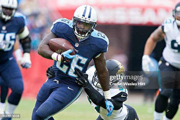 Antonio Andrews of the Tennessee Titans is grabbed from behind by Thurston Armbrister of the Jacksonville Jaguars at Nissan Stadium on December 6,...