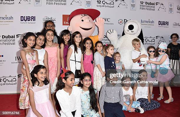 Characters Charlie Brown and Snoopy with young guests as they attend "The Peanuts Movie" premiere during day three of the 12th annual Dubai...