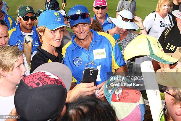 Adam Gilchrist of the Legends poses with spectators for photos following the WA Festival of Cricket Legends Match between the Australian Legends XI...
