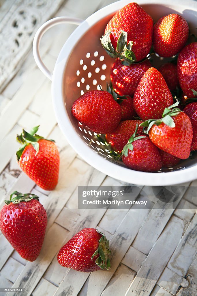 Strawberries in colander on table