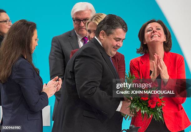 Social Democratic Party leader, German Vice Chancellor, Economy and Energy Minister Sigmar Gabriel holds a bouquet as SPD General Secretary Yasmin...