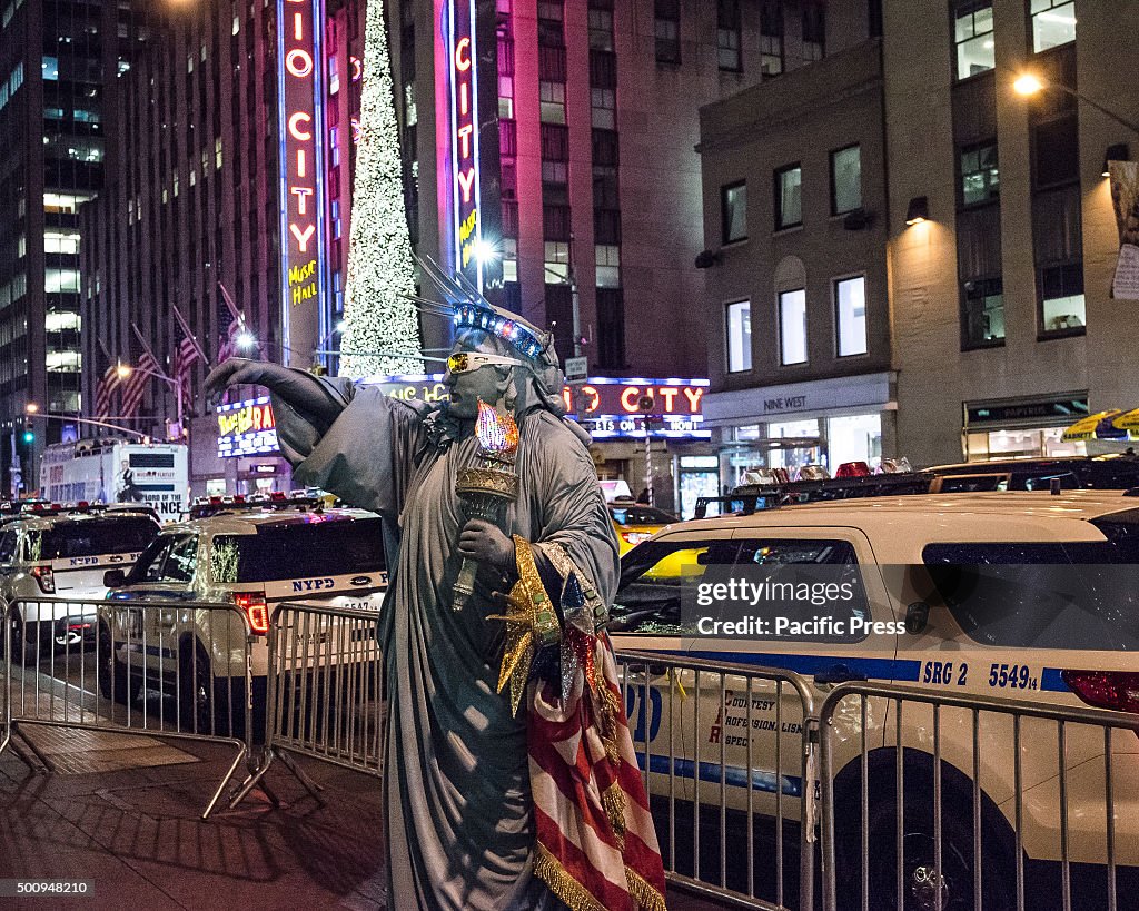 A street performer dressed as the Statue of Liberty poses...