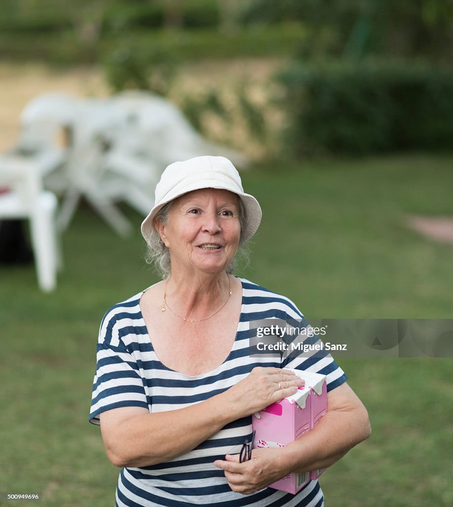 Elderly woman smiling with carton of milk