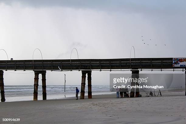 News crew gathers under pier as storm hits Daytona Beach Shores, Florida during Tropical Storm / Hurricane Arthur on July 2, 2014