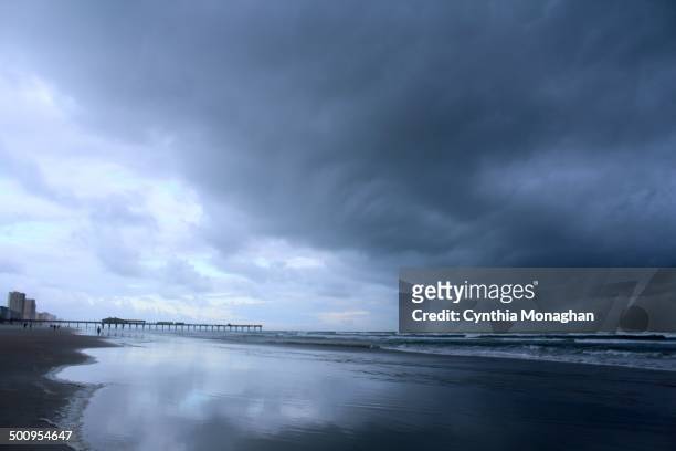 Swirling dark clouds reflected in water at the shore as Tropical Storm / Hurricane Arthur passes Daytona Beach Shores, Florida on July 2, 2014