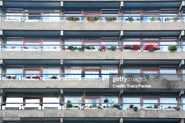 Window boxes of vibrant floral displays, line the balconies of the Grade II Listed Brutalist tower blocks at the Barbican Estate, in the heart of the...