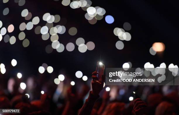Concert goers hold up their cellphones with torch lights switched on for peace as Tunisian singer-songwriter Emel Mathlouthi performs on stage during...