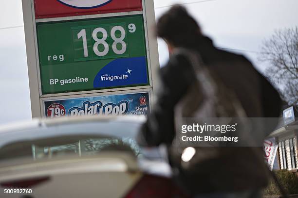 Customer fills her vehicle with fuel at a gas station in Chillicothe, Illinois, U.S., on Friday, Dec. 11, 2015. The cost of a gallon of regular...