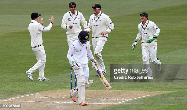 Martin Guptill of New Zealand celebrates taking a catch with Tom Latham, Ross Taylor and BJ Watling to dismiss Dinesh Chandimal of Sri Lanka during...