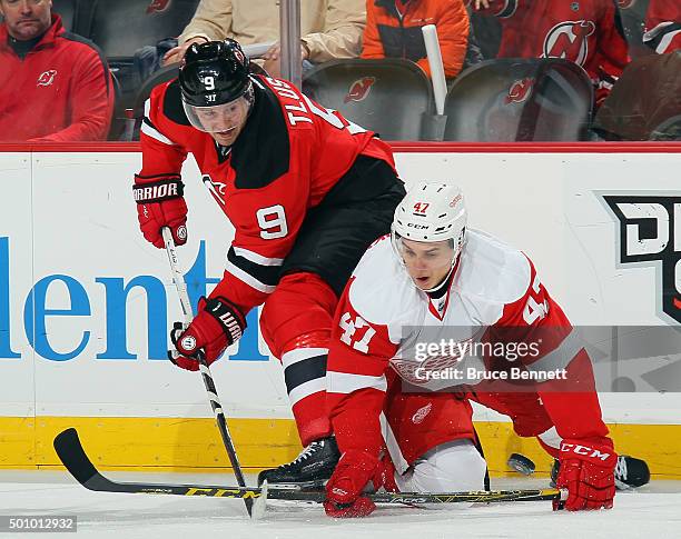 Jiri Tlusty of the New Jersey Devils and Alexei Marchenko of the Detroit Red Wings battle for the puck during the second period at the Prudential...