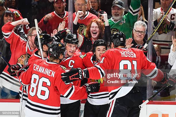 Jonathan Toews and Andrew Shaw of the Chicago Blackhawks celebrate with teammates after Toews scored against the Winnipeg Jets in the first period of...