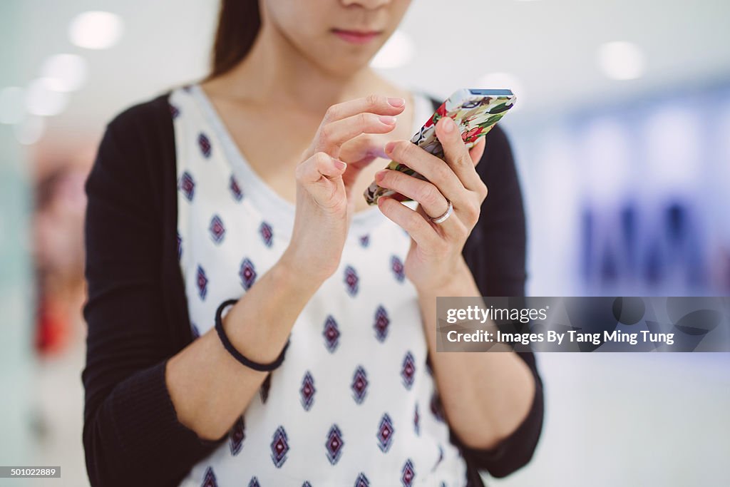Young lady using smartphone in mall