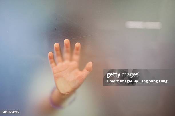 close up of little girl's hand against the glass - frosted glass ストックフォトと画像