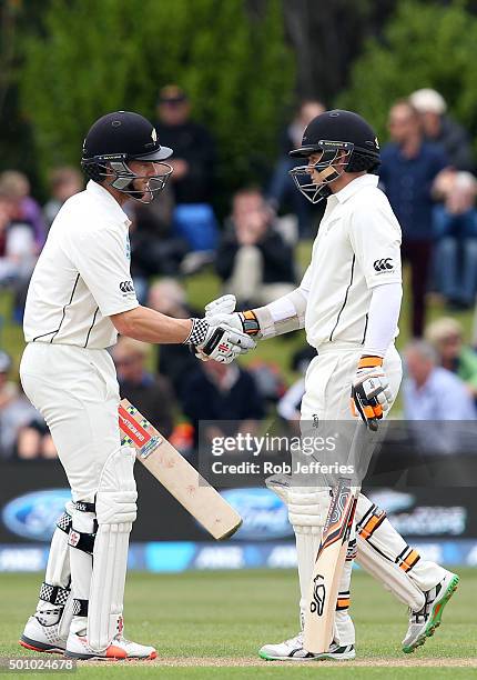 Tom Latham of New Zealand is congratulated by Kane Williamson after scoring 50 runs during day three of the First Test match between New Zealand and...