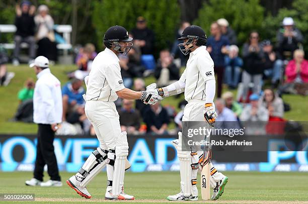 Tom Latham of New Zealand is congratulated by Kane Williamson after scoring 50 runs during day three of the First Test match between New Zealand and...