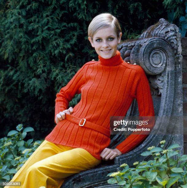 Sixties Fashion - English model Twiggy poses wearing a knitted red sweater with military styling and yellow trousers in 1967.