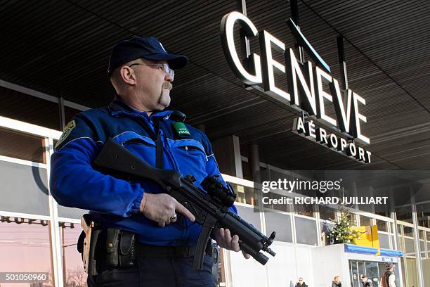 An armed policeman patrols on December 12, 2015 at Geneva Airport in Geneva. Two men of Syrian origin were arrested on December 11 in Geneva with...