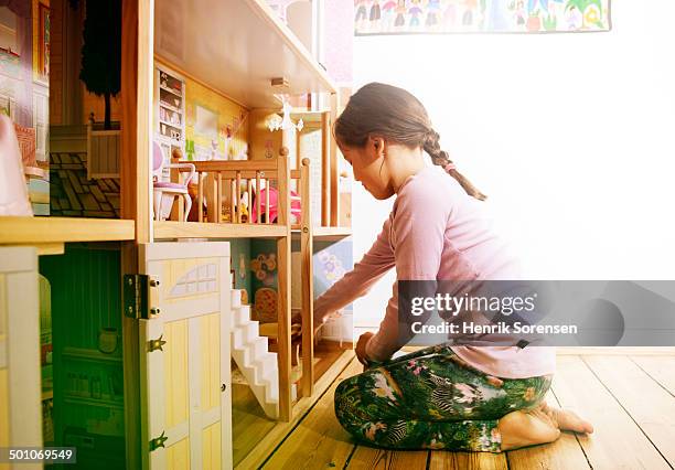 young girl playing with dollhouse - dollhouse stockfoto's en -beelden