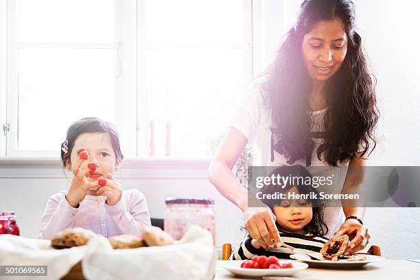 mother and 2 daughters eating breakfast - family with two children stock pictures, royalty-free photos & images