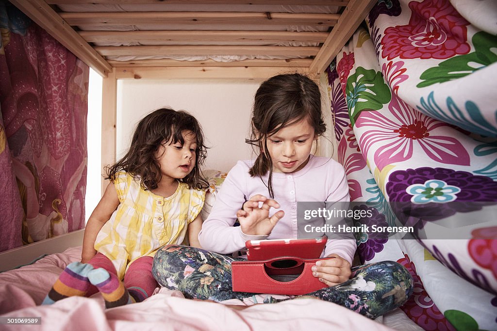 2 young girls playing with tablet