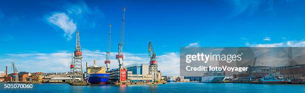 shipyard cranes boats and ferries in blue harbour helsinki finland - aangemeerd stockfoto's en -beelden