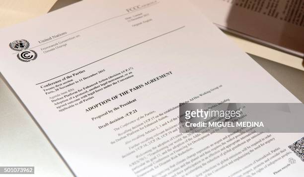 Copy of "The adoption of the Paris agreement" is pictured after the announcement of the final draft by French Foreign Affairs minister Laurent Fabius...