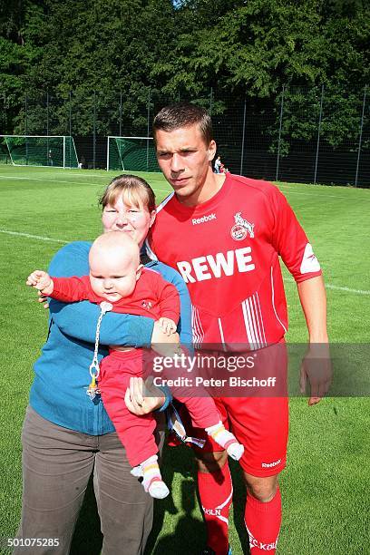 Lukas Podolski, Fan, PK, Sportplatz vom "1. FC Köln", Köln, Nordrhein-Westfalen, Deutschland, Europa, Logo, Werbung, Sponsor, Baby, auf dem Arm,...