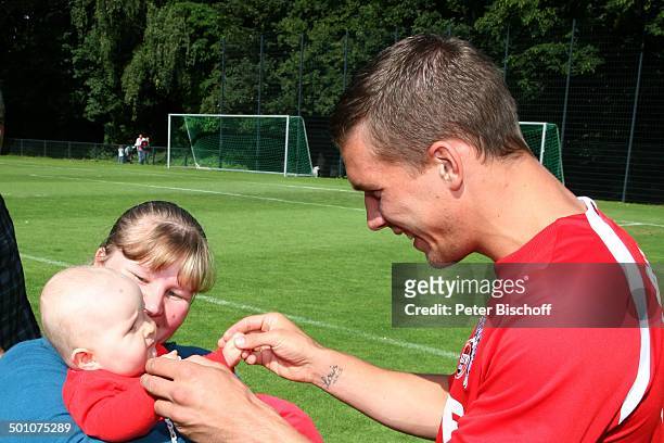 Lukas Podolski, Fan, PK, Sportplatz vom "1. FC Köln", Köln, Nordrhein-Westfalen, Deutschland, Europa, Logo, Werbung, Sponsor, Baby, auf dem Arm,...