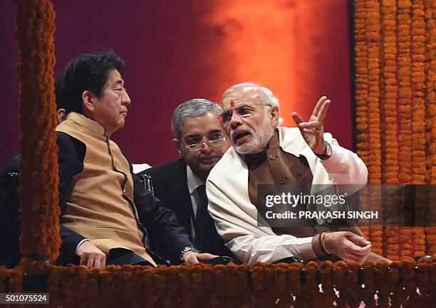 Japan's Prime Minister Shinzo Abe and India's Prime Minister Narendra Modi talk as they attend the evening 'Aarti' ritual on the banks of the River...