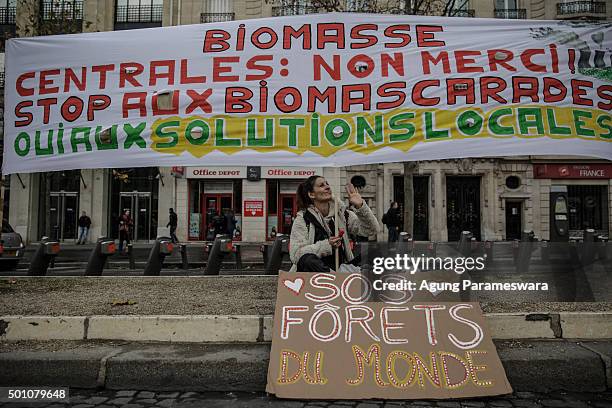 An activist waves her hand during a demonstration near the Arc de Triomphe at the Avenue de la Grande Armee boulevard on December 12, 2015 in Paris,...