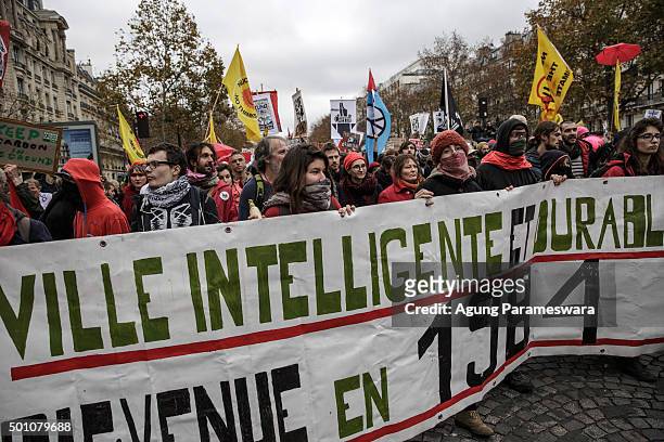 Activists gather as they shouts and hold banner during a demonstration near the Arc de Triomphe at the Avenue de la Grande Armee boulevard on...
