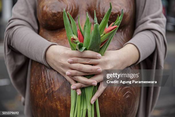 An activist holds tulip flowers during a demonstration near the Arc de Triomphe at the Avenue de la Grande Armee boulevard on December 12, 2015 in...