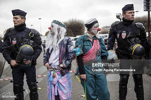 Two activists perform beside the police as they attend a demonstration near the Arc de Triomphe at the Avenue de la Grande Armee boulevard on...