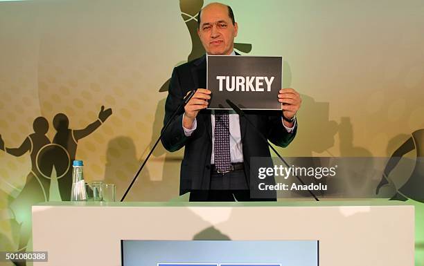 President of The International Basketball Federation Europe Turgay Demirel holds a banner reading "Turkey" to announce that Turkey will host...