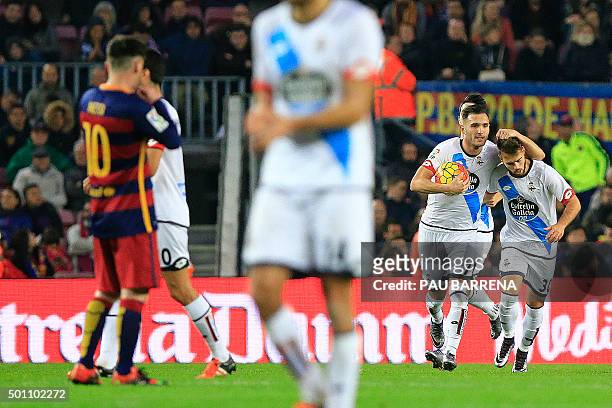 Deportivo de La Coruna's Spanish midfielder Lucas Perez holds the ball after scoring a goal as he celebrates with teammate Deportivo La Coruna's...