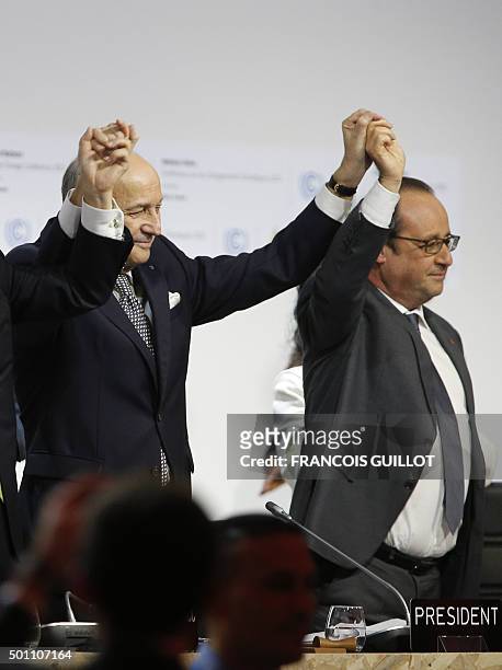 French Foreign Affairs Minister and President-designate of the COP21 Laurent Fabius and French President Francois Hollande raise their hands after...