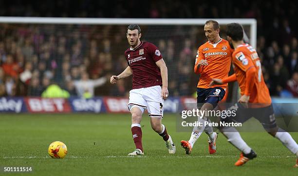 Xander Diamond of Northampton Town plays the ball watched by Paul Benson of Luton Town during the Sky Bet League Two match between Luton Town and...
