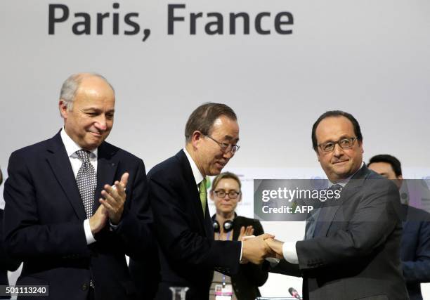 French President Francois Hollande shakes hands with UN secretary general Ban Ki-moon next to French Foreign Minister and COP21 president Laurent...