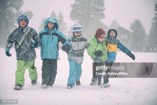 children running and playing in the snow during a storm - family with five children stock pictures, royalty-free photos & images
