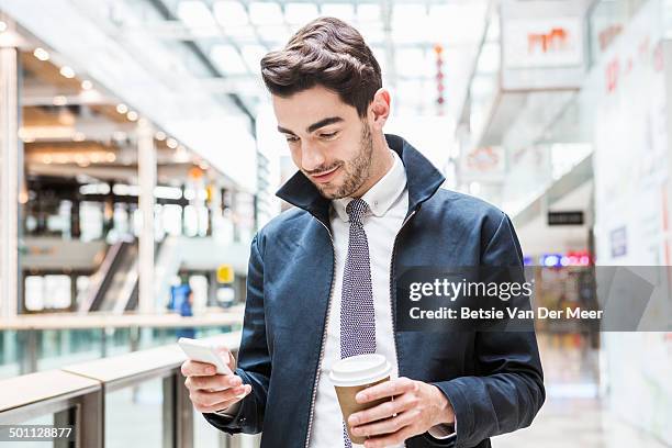 man looking at mobile phone in shopping centre. - shirt and tie stock pictures, royalty-free photos & images