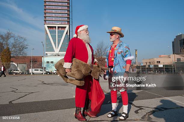 Two men dressed as Santa talk before the start of the annual SantaCon pub crawl December 12, 2015 in the Brooklyn borough of New York City. Hundreds...