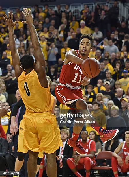 Guard Brandon Taylor of the Utah Utes passes the ball around defender Rashard Kelly of the Wichita State Shockers during the second half on December...